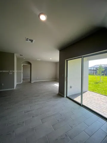 a view of an empty room with a fireplace and a window