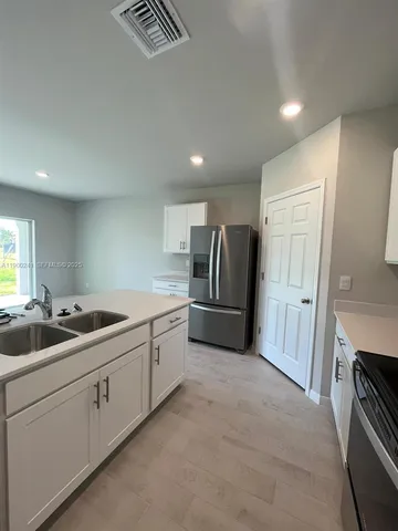 a kitchen with sink and refrigerator