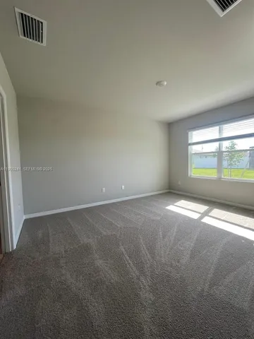 an empty room with floor to ceiling windows and ceiling fan
