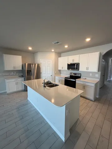 a large kitchen with stainless steel appliances and a refrigerator