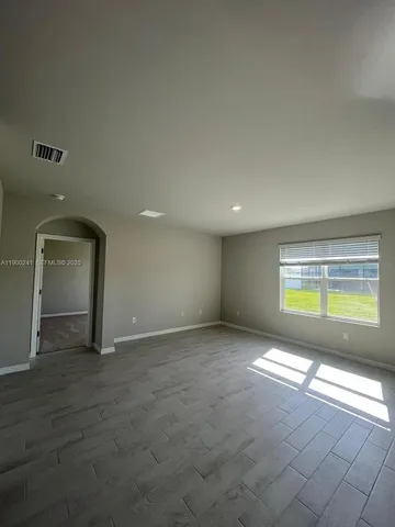 an empty room with windows and closet