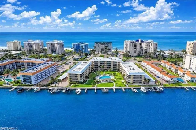 a front view of a building with lots of cars parked