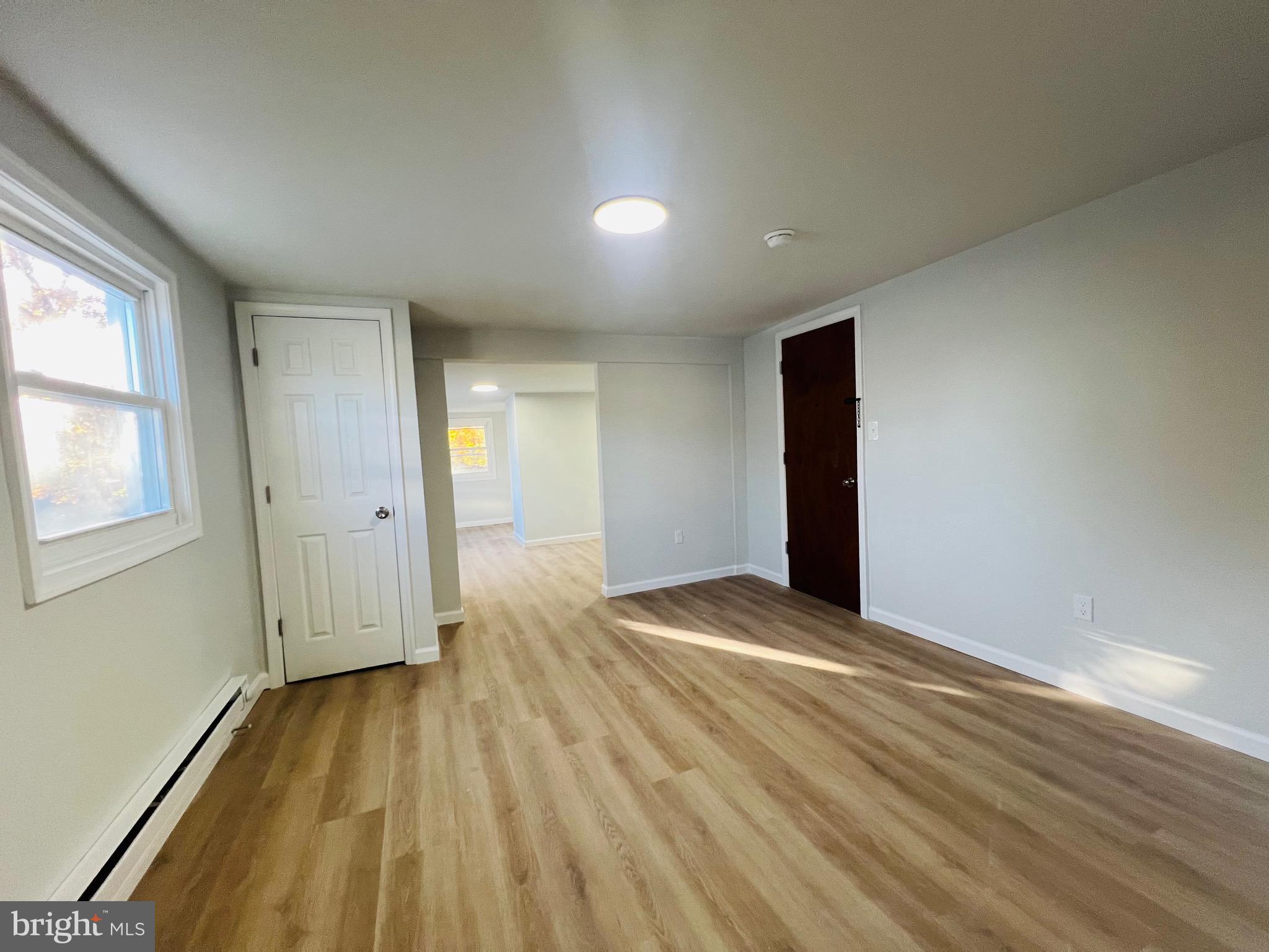 401 Blue Bell Road, Unit E Williamstown, NJ 08094 - Photo 3 of 11 a view of an empty room with wooden floor and a window