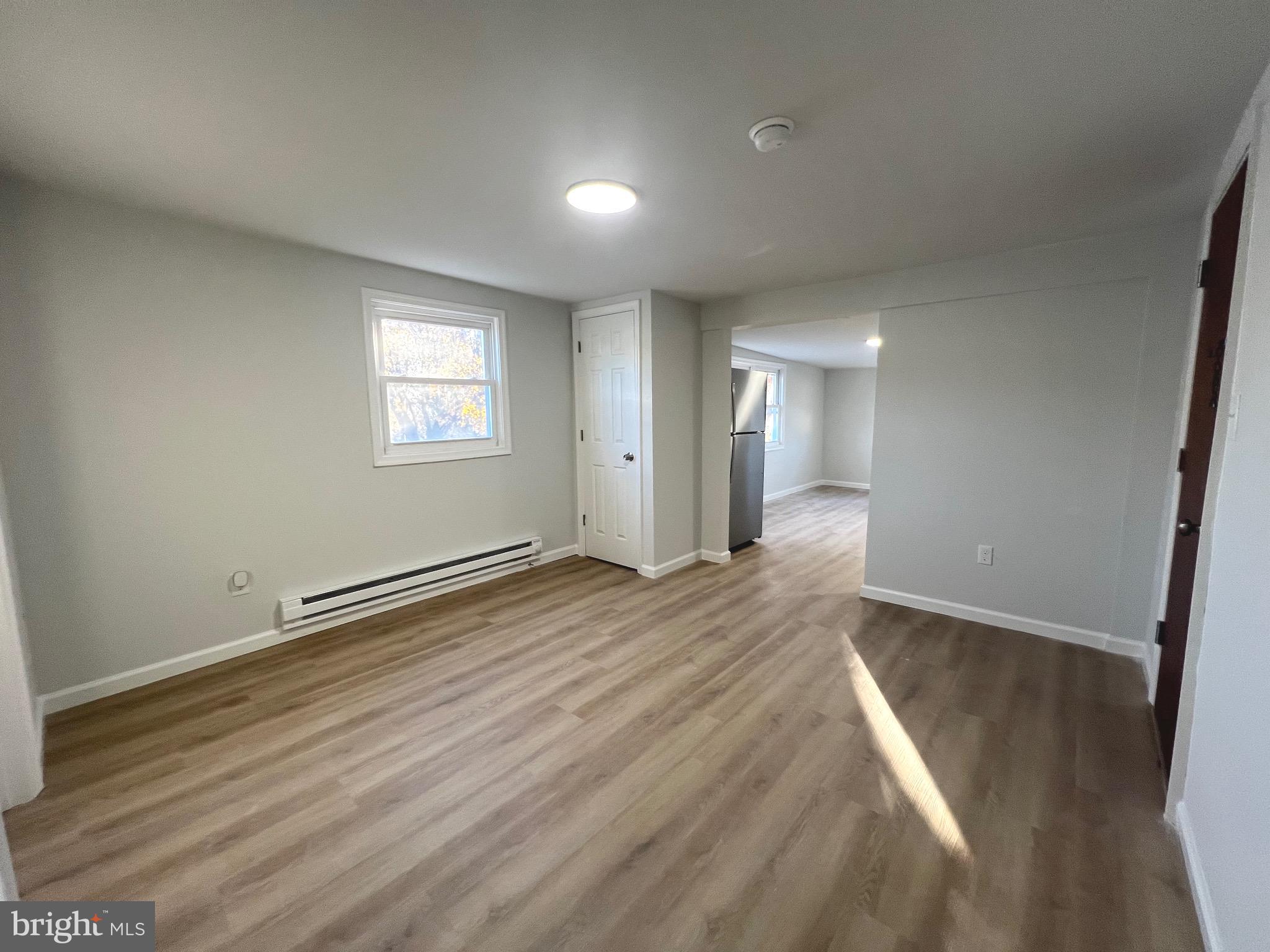 401 Blue Bell Road, Unit E Williamstown, NJ 08094 - Photo 4 of 11 an empty room with wooden floor and windows