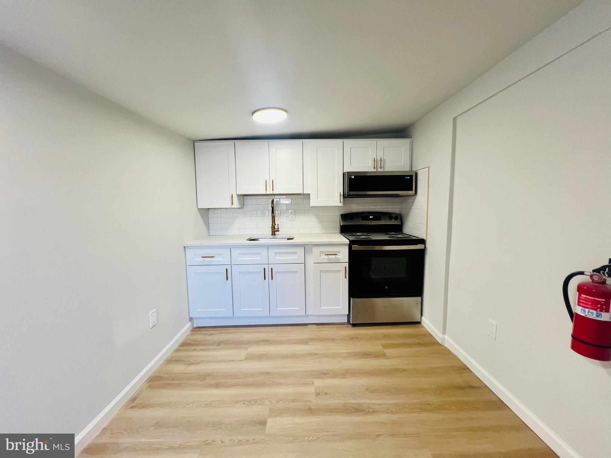401 Blue Bell Road, Unit E Williamstown, NJ 08094 - Photo 7 of 11 a kitchen with stainless steel appliances a stove top oven a sink and dishwasher