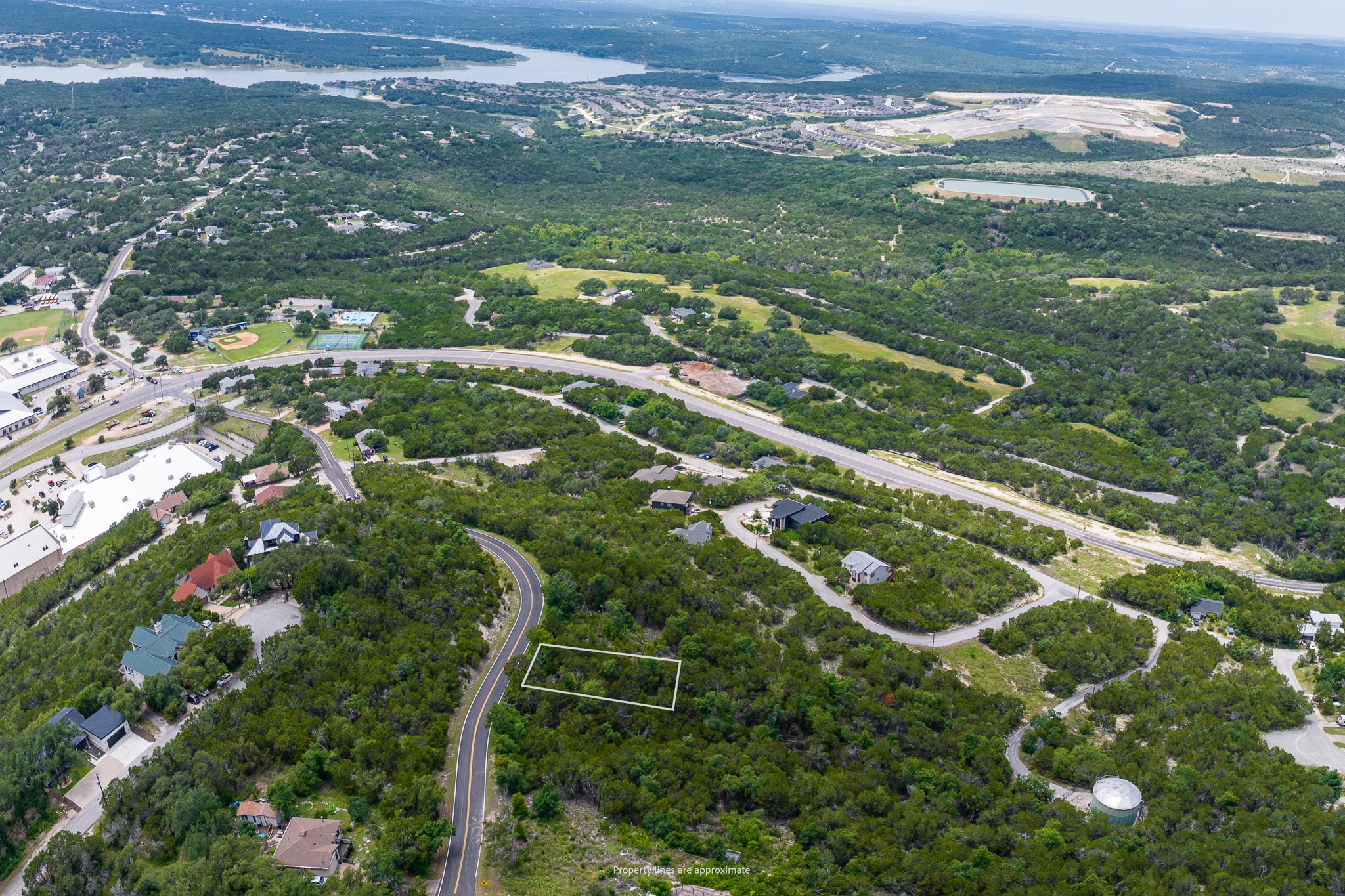 8220 Bar K Ranch Road Lago Vista, TX 78645 - Photo 2 of 8 A vast aerial perspective showcasing a scenic residential area surrounded by abundant trees and distant water features.