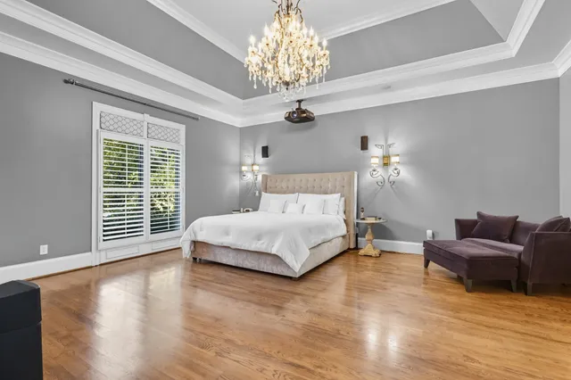 a spacious bedroom with a bed and a chandelier