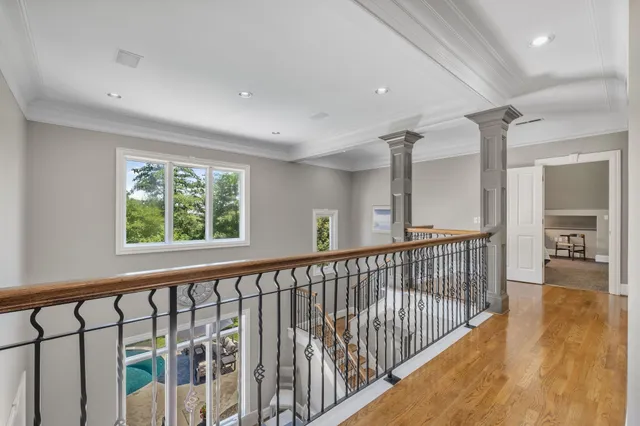 a view of a hallway with wooden floor and stairs