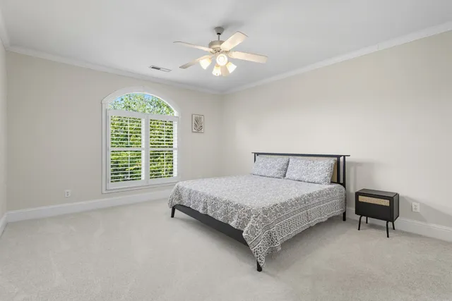 a spacious bedroom with a bed and a chandelier