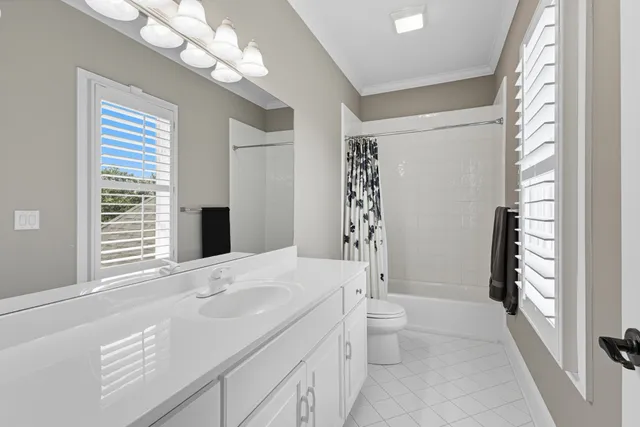 a bathroom with a granite countertop sink a large mirror and a toilet