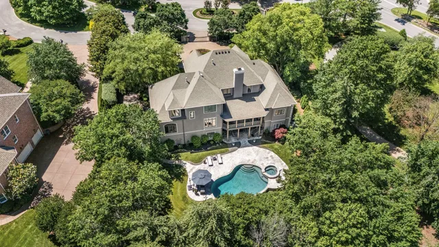 an aerial view of a house with swimming pool and garden