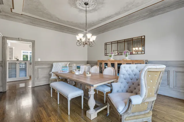 a dining room with furniture a chandelier and wooden floor