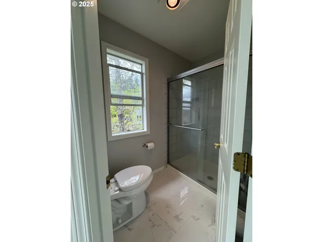 a balcony with wooden floor and trees in the background