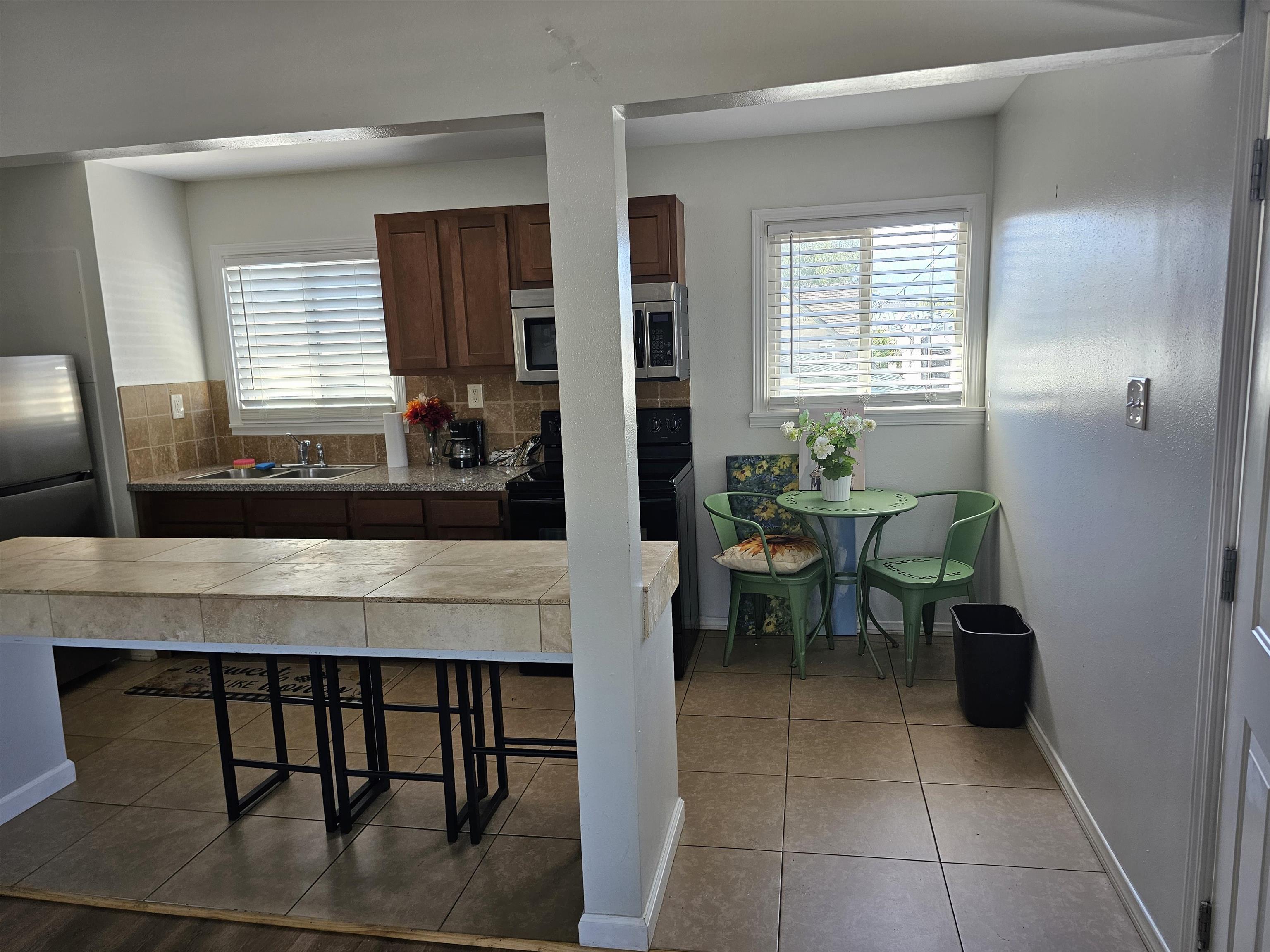 461 High Street Bishop, CA 93514 - Photo 5 of 10 Kitchen area featuring wood cabinetry, stone countertops, and a tiled backsplash
