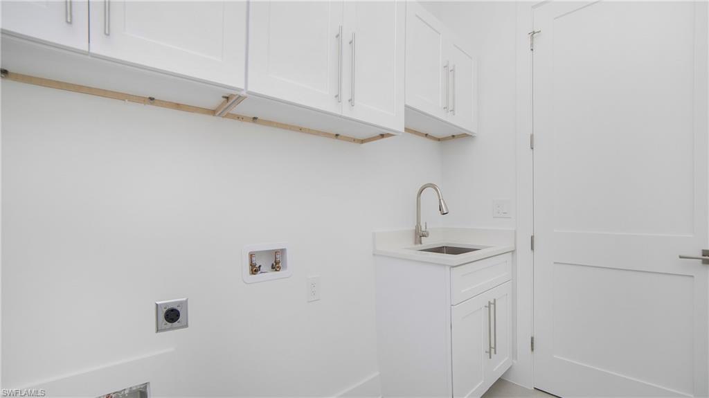2343 Oil Well Road Naples, FL 34120 - Photo 23 of 46 Laundry area featuring white cabinetry, a utility sink with a brushed nickel faucet, and a solid white door with brushed nickel hardware