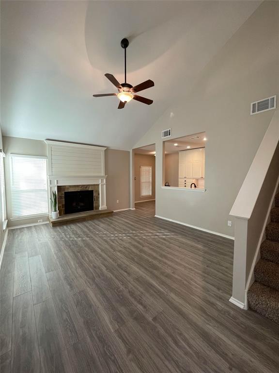 2917 Roxboro Road Euless, TX 76039 - Photo 4 of 20 an empty room with wooden floor fireplace and a ceiling fan