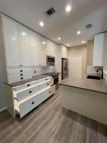 a kitchen with stainless steel appliances a refrigerator sink and cabinets