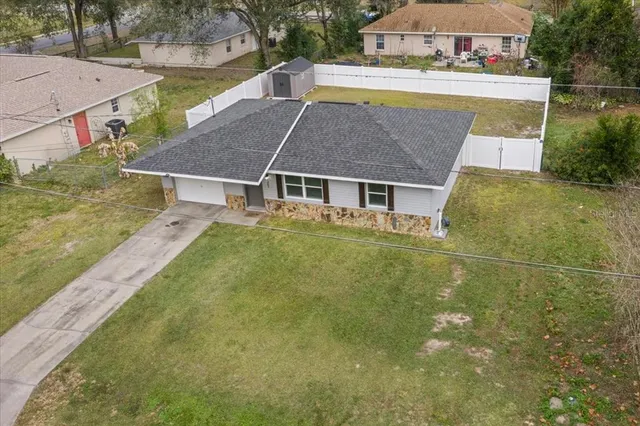 a aerial view of a house with swimming pool and a yard