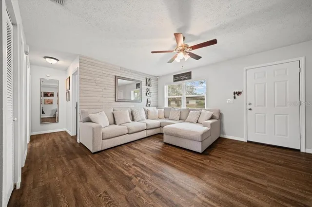 a living room with furniture and a wooden floor