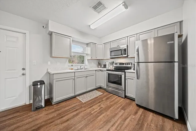 a kitchen with stainless steel appliances a refrigerator sink and cabinets