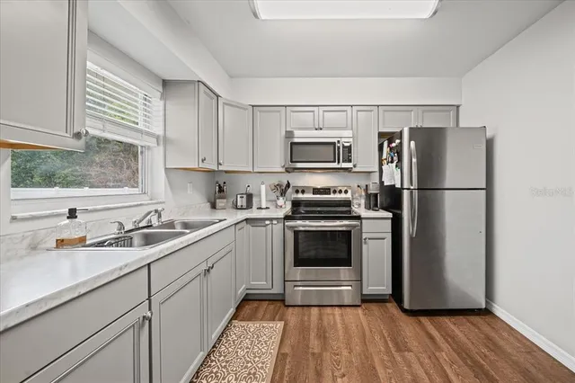 a kitchen with a sink a refrigerator and a stove top oven