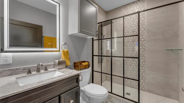 a bathroom with a granite countertop sink toilet and shower