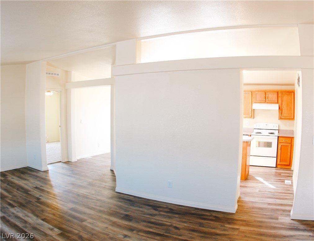 5231 Ruby Way Caliente, NV 89008 - Photo 16 of 35 Rich wood-look flooring extends through an open-concept living area into an adjacent, naturally illuminated kitchen.