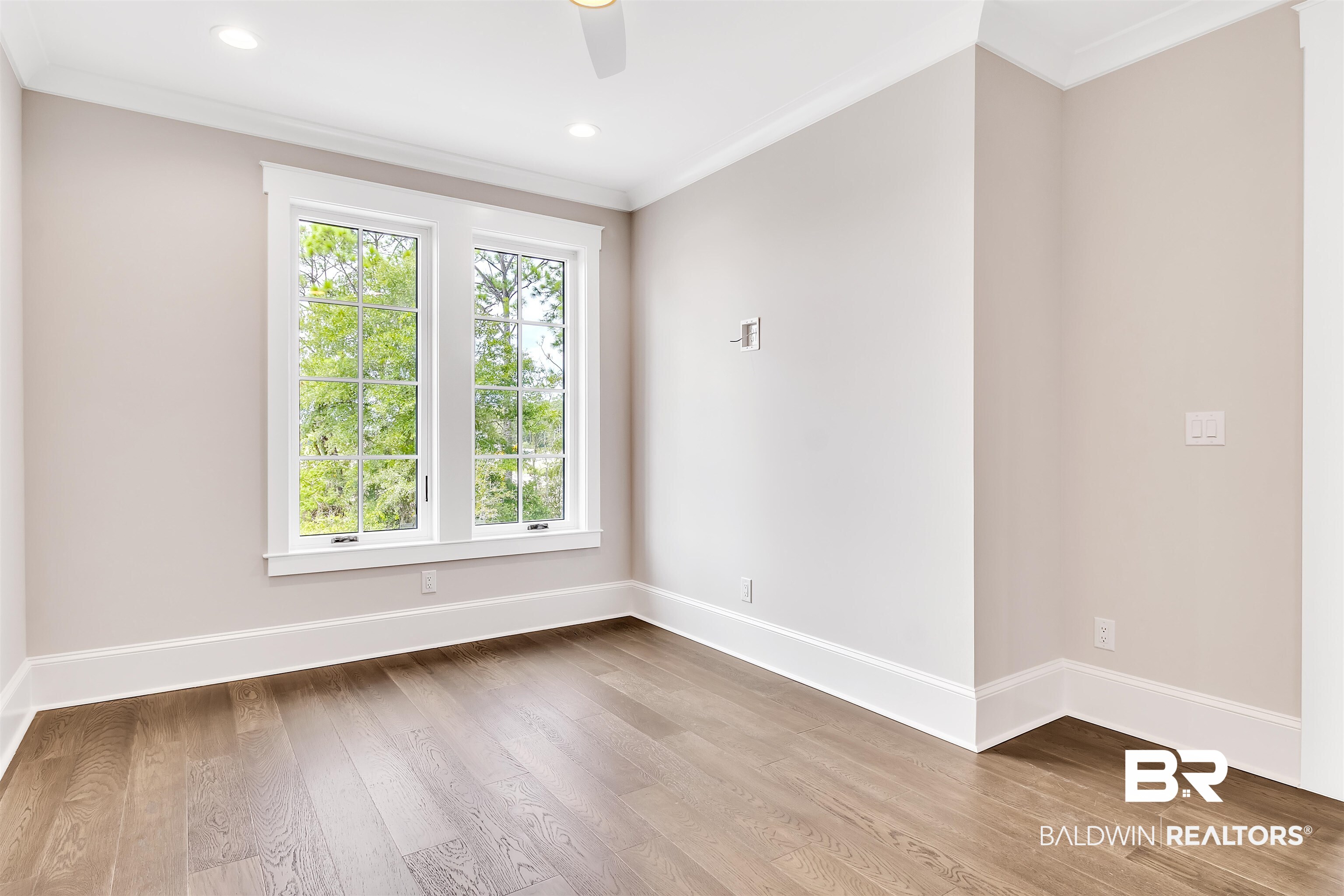 829 Inlet Circle Gulf Shores, AL 36542 - Photo 15 of 31 Unfurnished room featuring crown molding, a healthy amount of sunlight, ceiling fan, and hardwood / wood-style flooring