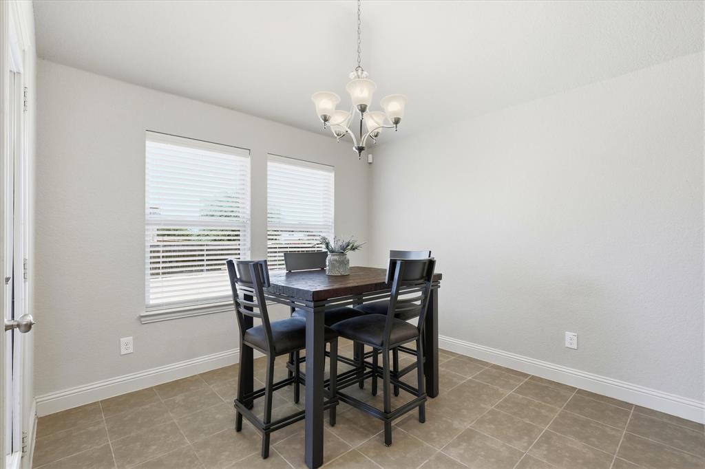 115 Blue Quail Road Red Oak, TX 75154 - Photo 11 of 35 Recessed dining area featuring tile flooring, two windows with blinds, and an attached five-light chandelier