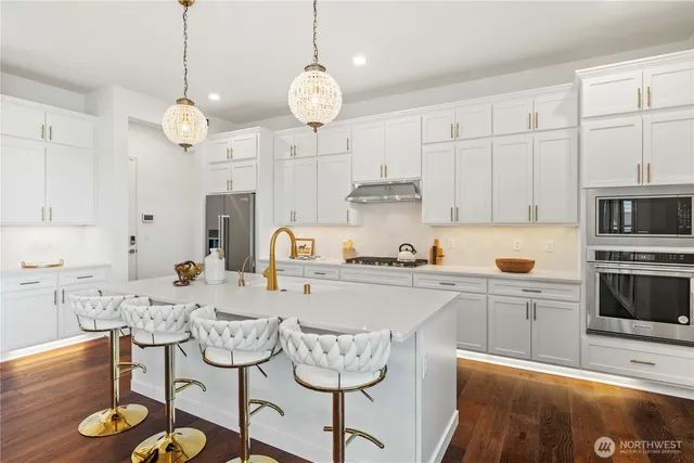 a kitchen with stainless steel appliances granite countertop a stove a sink and a refrigerator