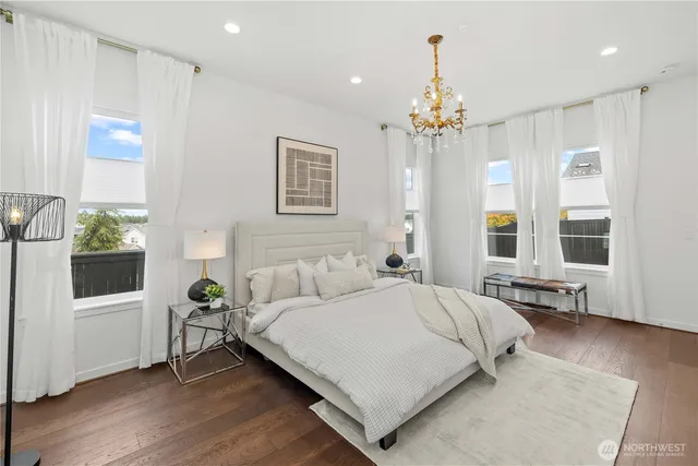 a bedroom with a bed chandelier and a window