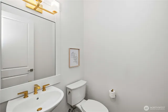 a bathroom with a sink mirror and toilet