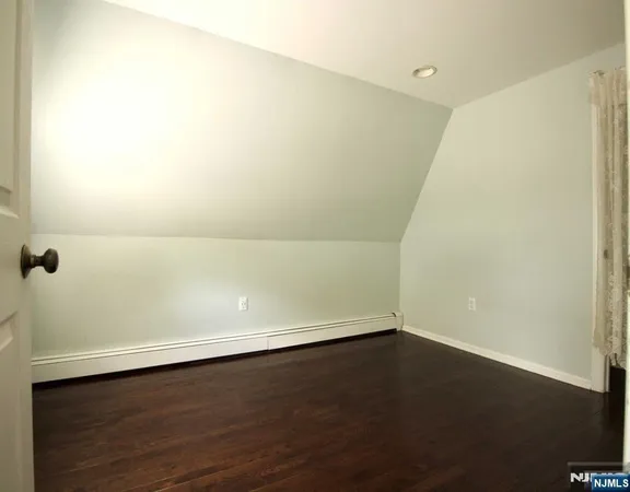 an empty room with a wooden floor and white wall