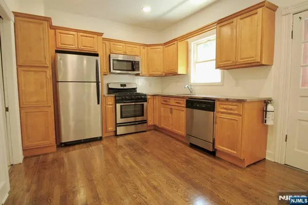 a kitchen with stainless steel appliances granite countertop a refrigerator microwave and sink
