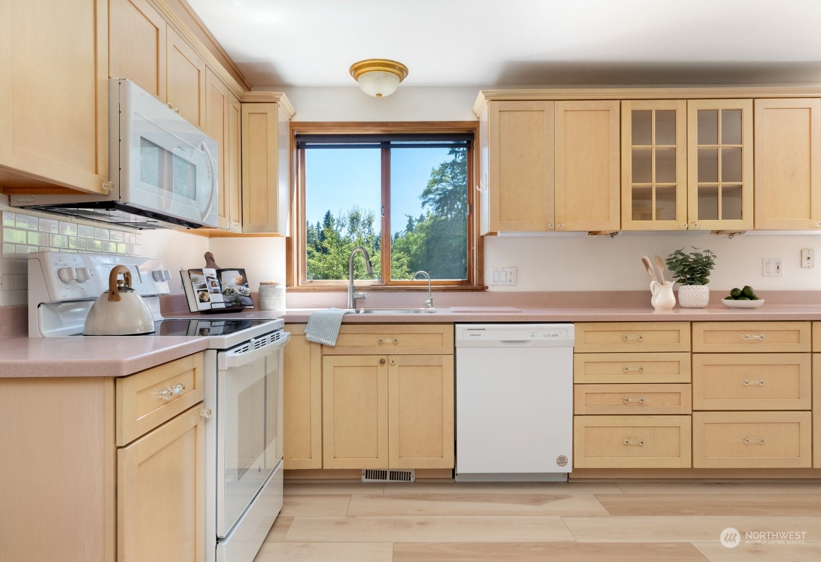 3550 Swede Hill Road Clinton, WA 98236 - Photo 9 of 40 a kitchen with granite countertop white cabinets and white appliances