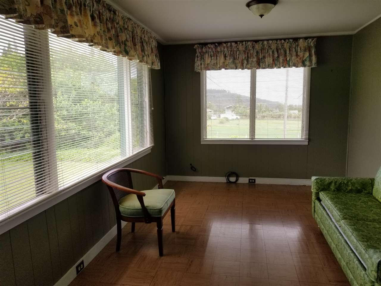 2165 Kokomo Road Haiku, HI 96708 - Photo 4 of 12 a view of a livingroom with lounge chair and windows