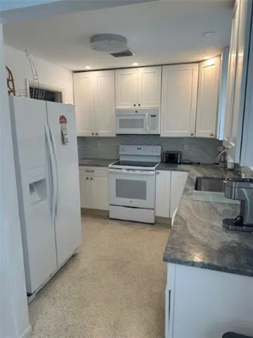 a kitchen with a refrigerator sink and stove