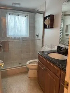 a bathroom with a granite countertop sink a toilet and mirror