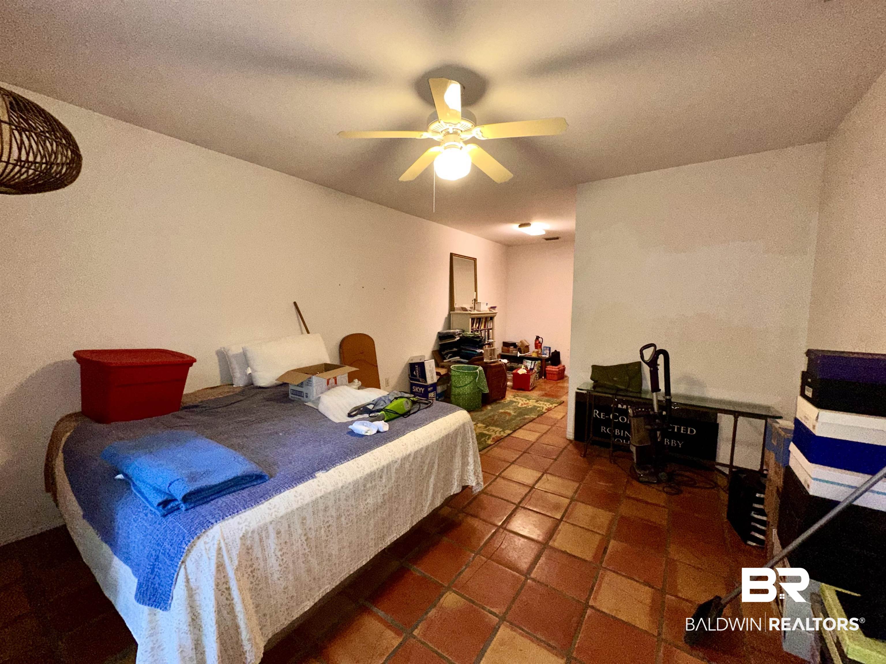 9101 Coronada Road Elberta, AL 36530 - Photo 12 of 27 Bedroom featuring tile patterned flooring, ceiling fan, and a textured ceiling