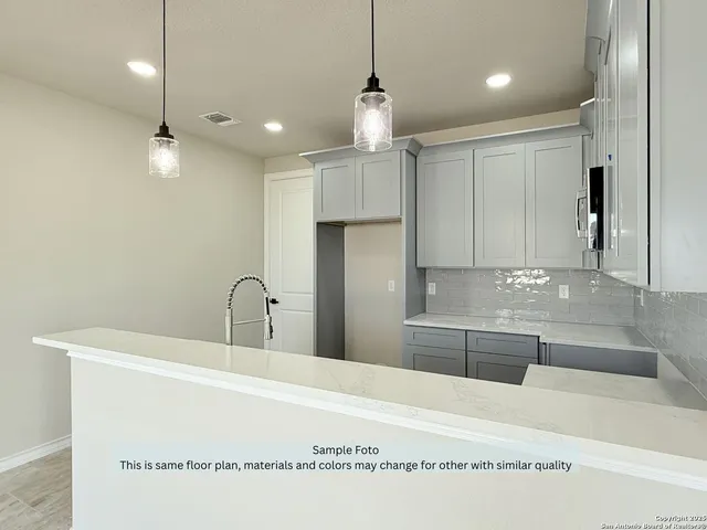 a kitchen with kitchen island a counter top space appliances and cabinets