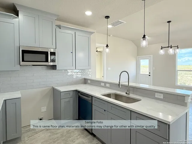 a kitchen with a sink and stainless steel appliances