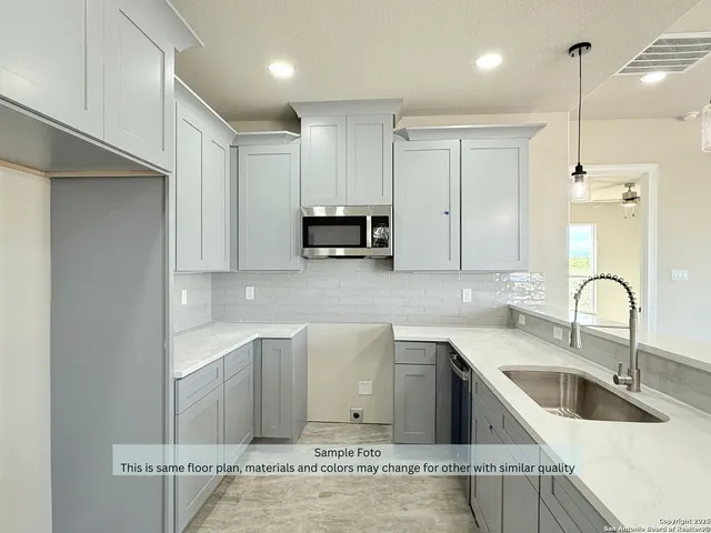 a kitchen with stainless steel appliances granite countertop a sink a stove and a refrigerator