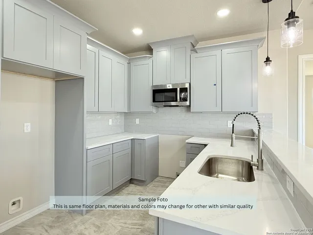 a kitchen with stainless steel appliances granite countertop a sink a stove and a refrigerator