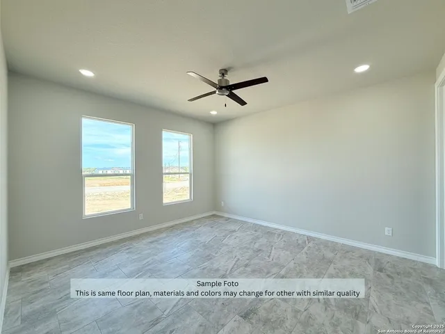 an empty room with windows and fan