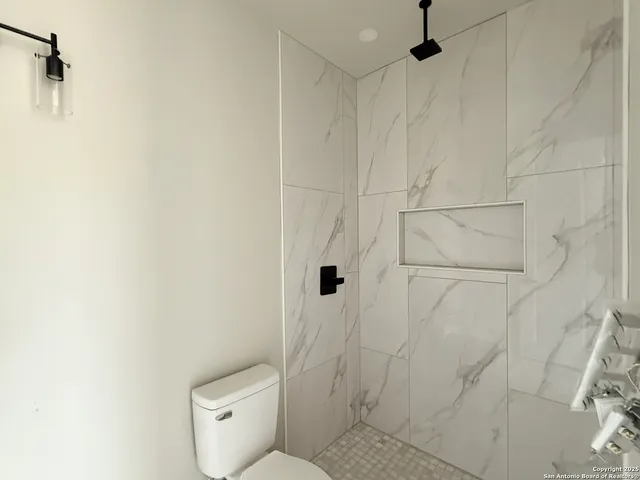 a white toilet sitting next to a shower curtain