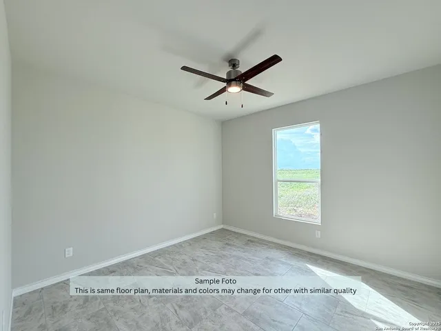 an empty room with a window and a ceiling fan