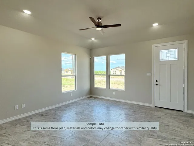 a view of an empty room and window ceiling fan