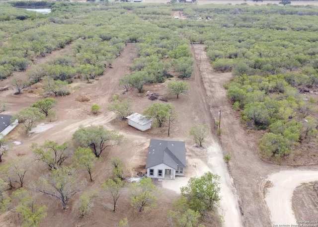a view of a field with trees in background