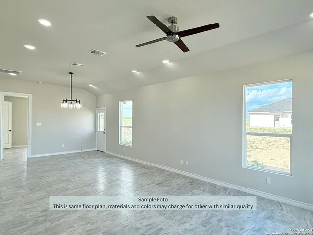 an empty room with windows and ceiling fan