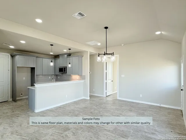 a large kitchen with a refrigerator a oven and a sink